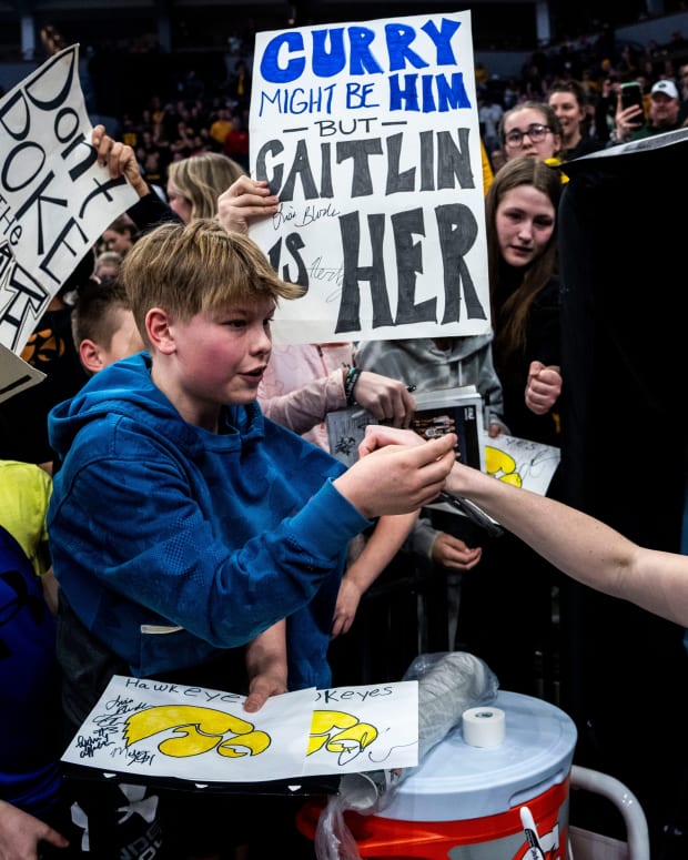 Iowa guard Caitlin Clark (22) gives a fan her headband during the Big Ten Women's Basketball tournament quarterfinals at the Target Center on Friday, March 8, 2024, in Minneapolis, Minn.